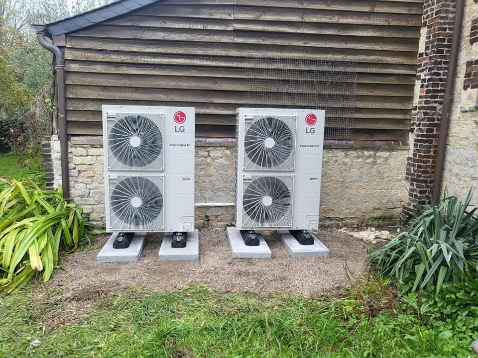 Deux pompes à chaleur LG installées devant un mur en pierre
